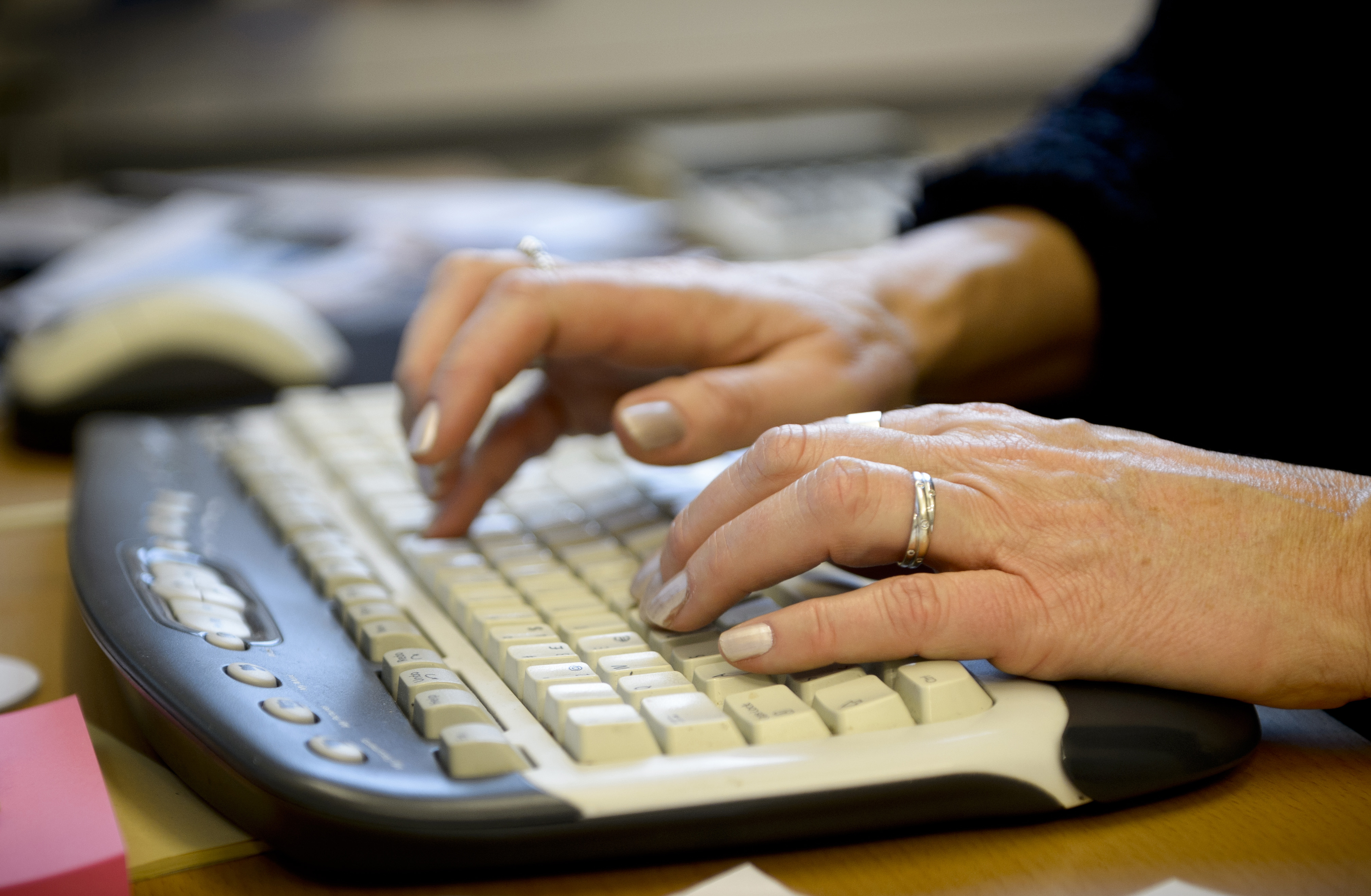 Woman typing on a computer keyboard. Photo.