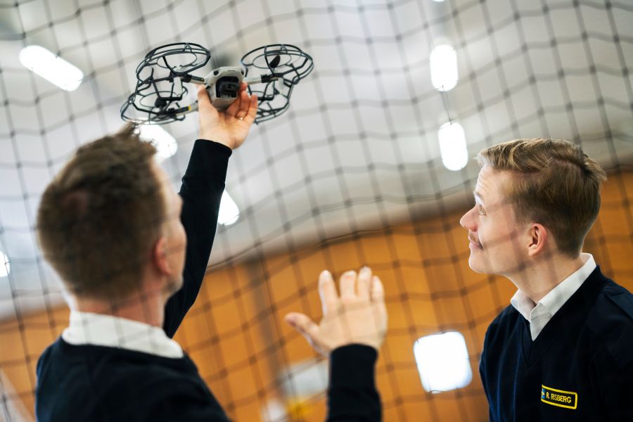 Students holding a drone. Photo.